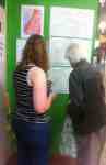 Jo Galloway at Leeds Market helps a man to sample smells a smell and record with a sticker